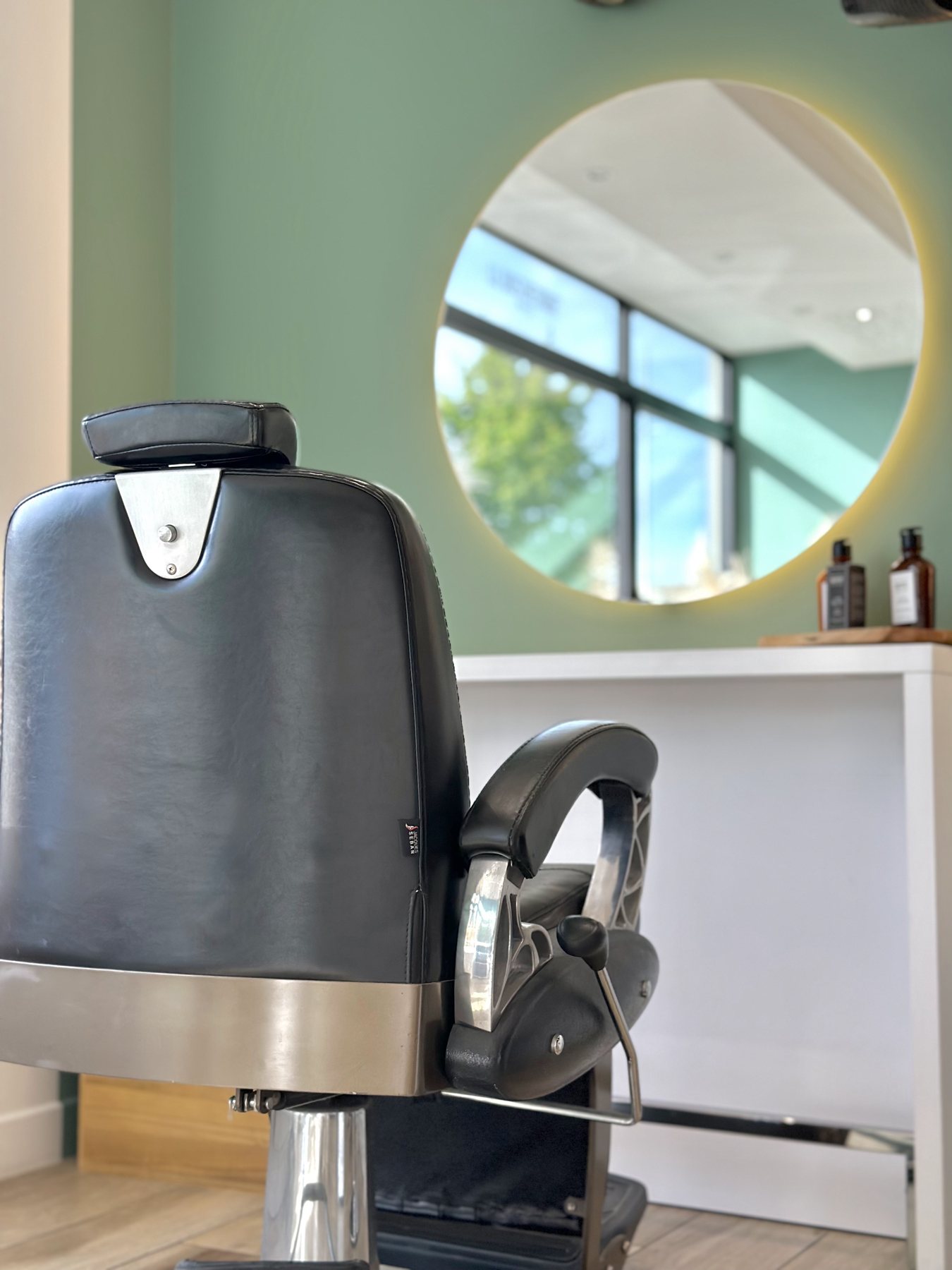 Fauteuil de barbier en cuir noir de l'espace barbier du salon, à Chalonnes-sur-Loire