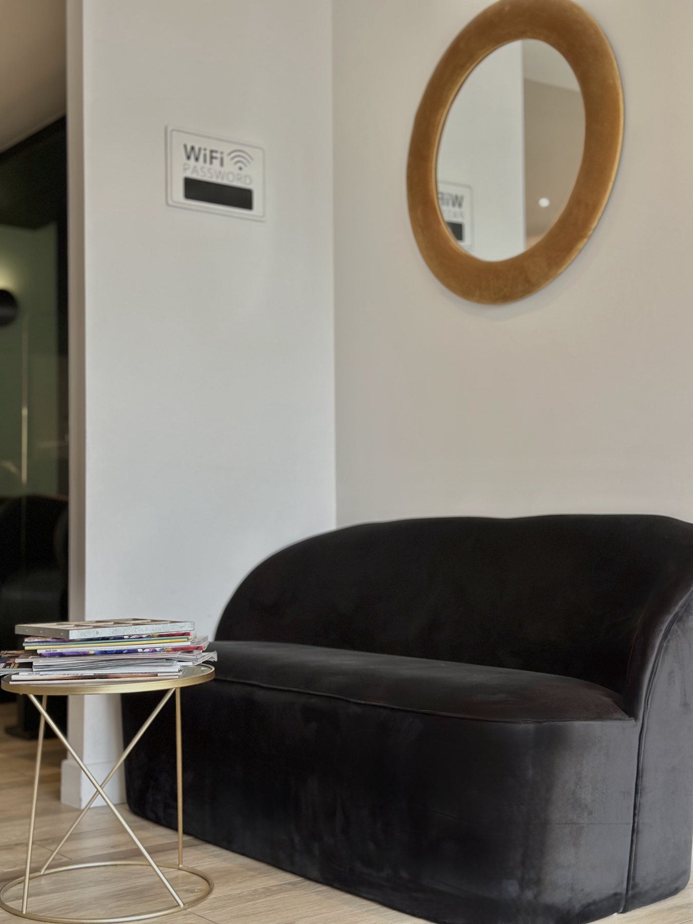 Le coin attente du salon, canapé en velours noir et miroir doré